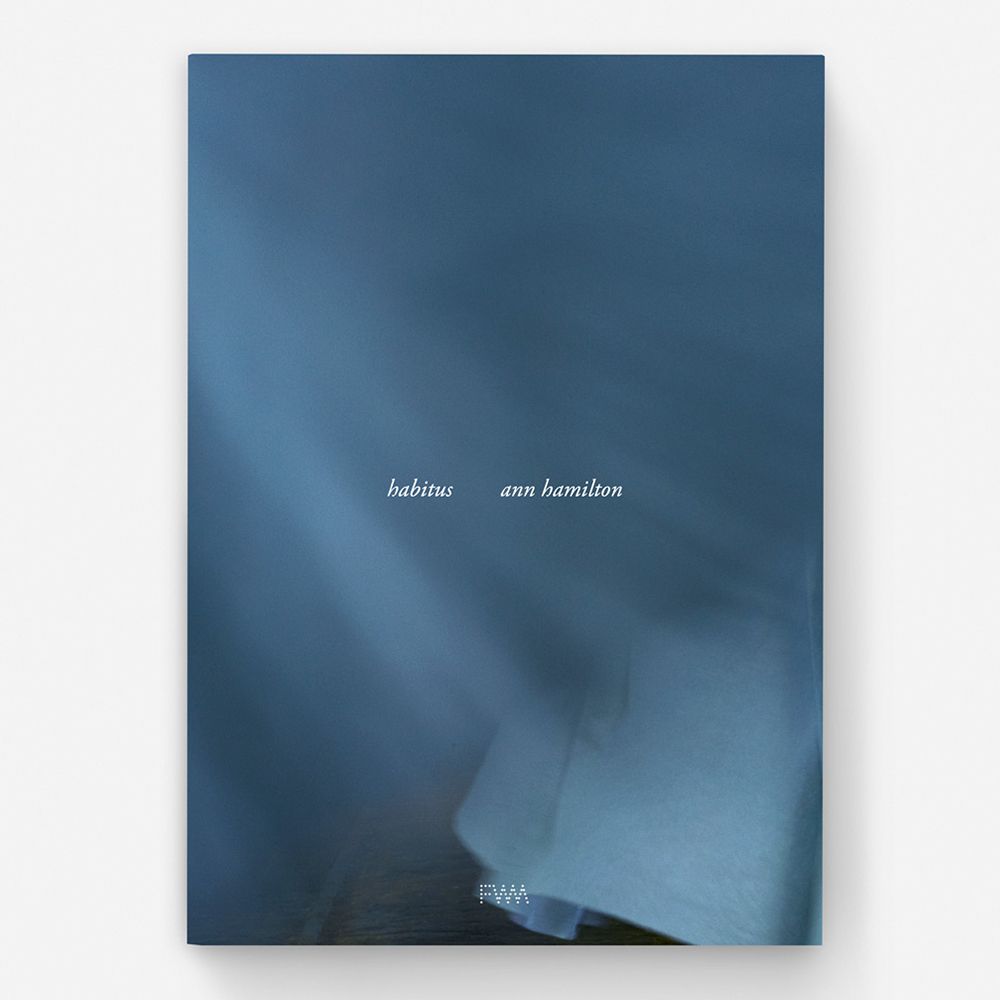 A hardback book with a cover featuring a photograph of a large dimly lit white cloth billowing in the wind. The title reads 