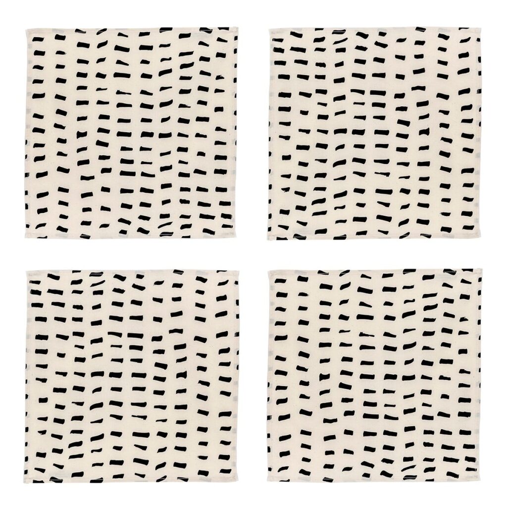 A set of four square napkins composed of cream-colored fabric with several rows of short brushstroke-like black dashes.