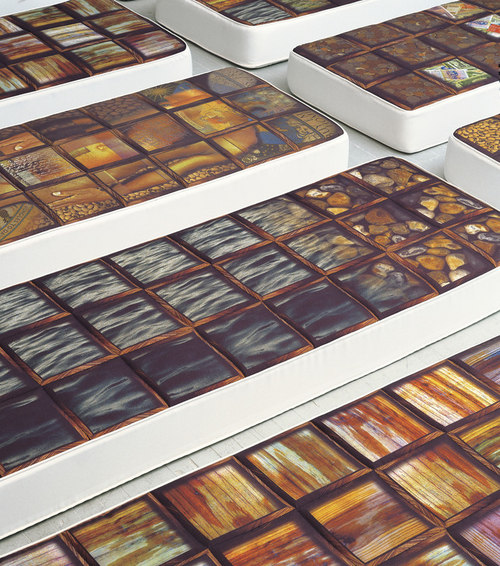 mattress features photographic prints with different materials, including coins, water, and grains.