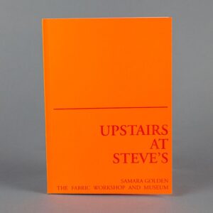 A photograph of a bright orange book standing upright. A red line divides the book cover into two; the lower half reads, 