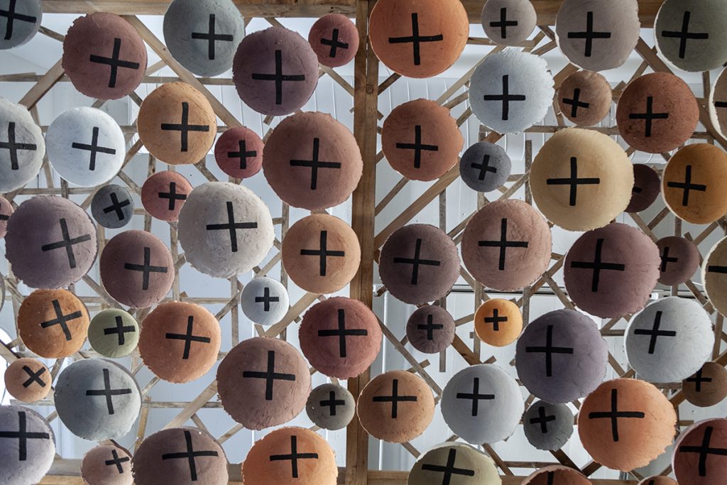A contemporary art installation by the artist Rose B. Simpson features a canopy of earth-toned baskets made by the artist. Each has a cross-like symbol, which she calls stars.