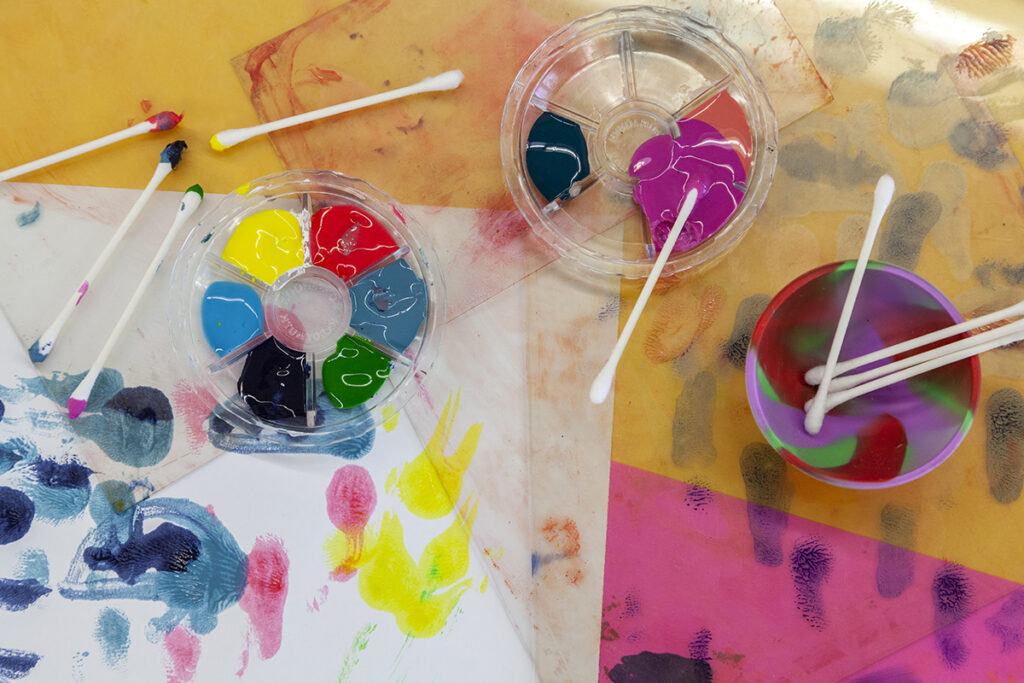 A set of colorful inks with q-tips used to apply the ink to plexiglass.
