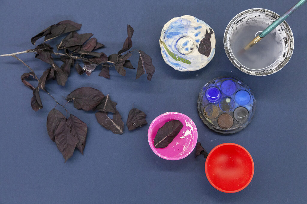 Dried leaves with an arrangement of slump molds to create clay bowls