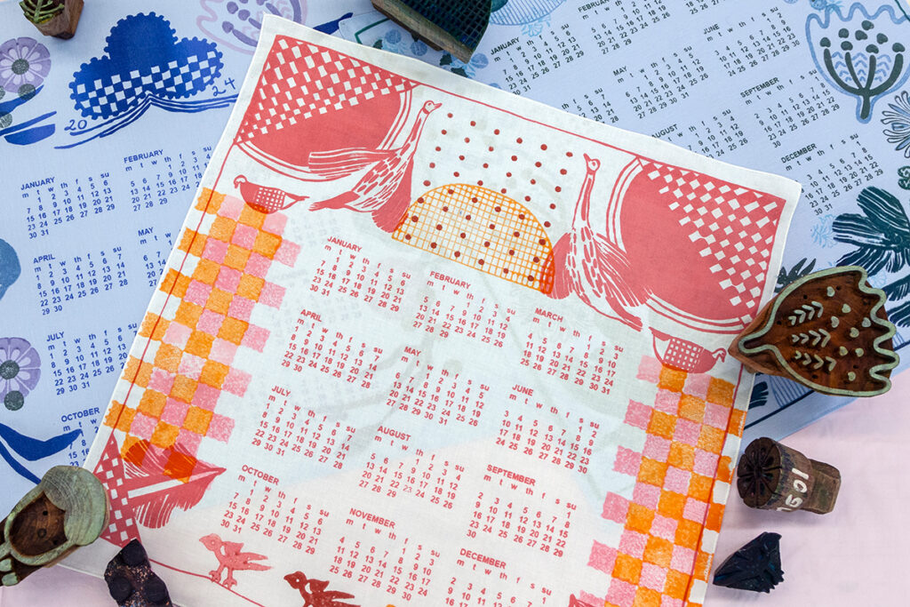 A few examples of single-page calendars printed with patterned blocks. The version on top is square-shaped and printed in warm colors with the year's dates printed in a grid in the center.