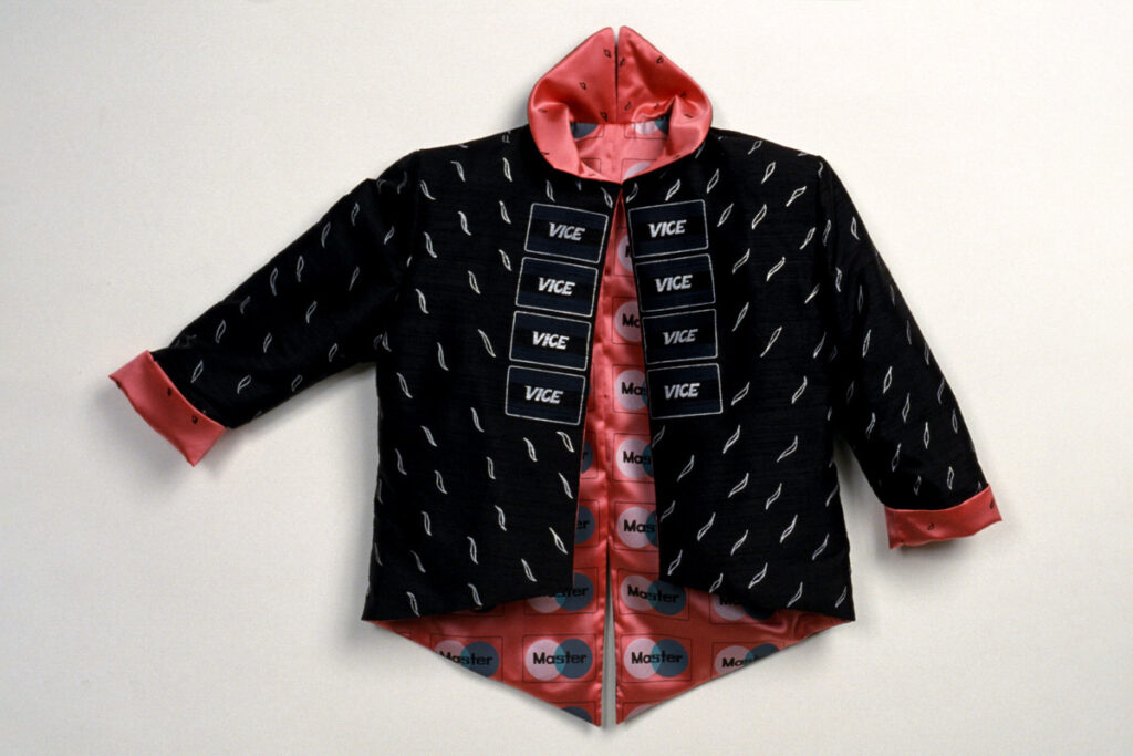 A black jacket with red fleshy lining. The pattern printed over the black exterior, near the seam, reads "Vice." On the lining, a pattern reading "Master" resembles the Mastercard logo.