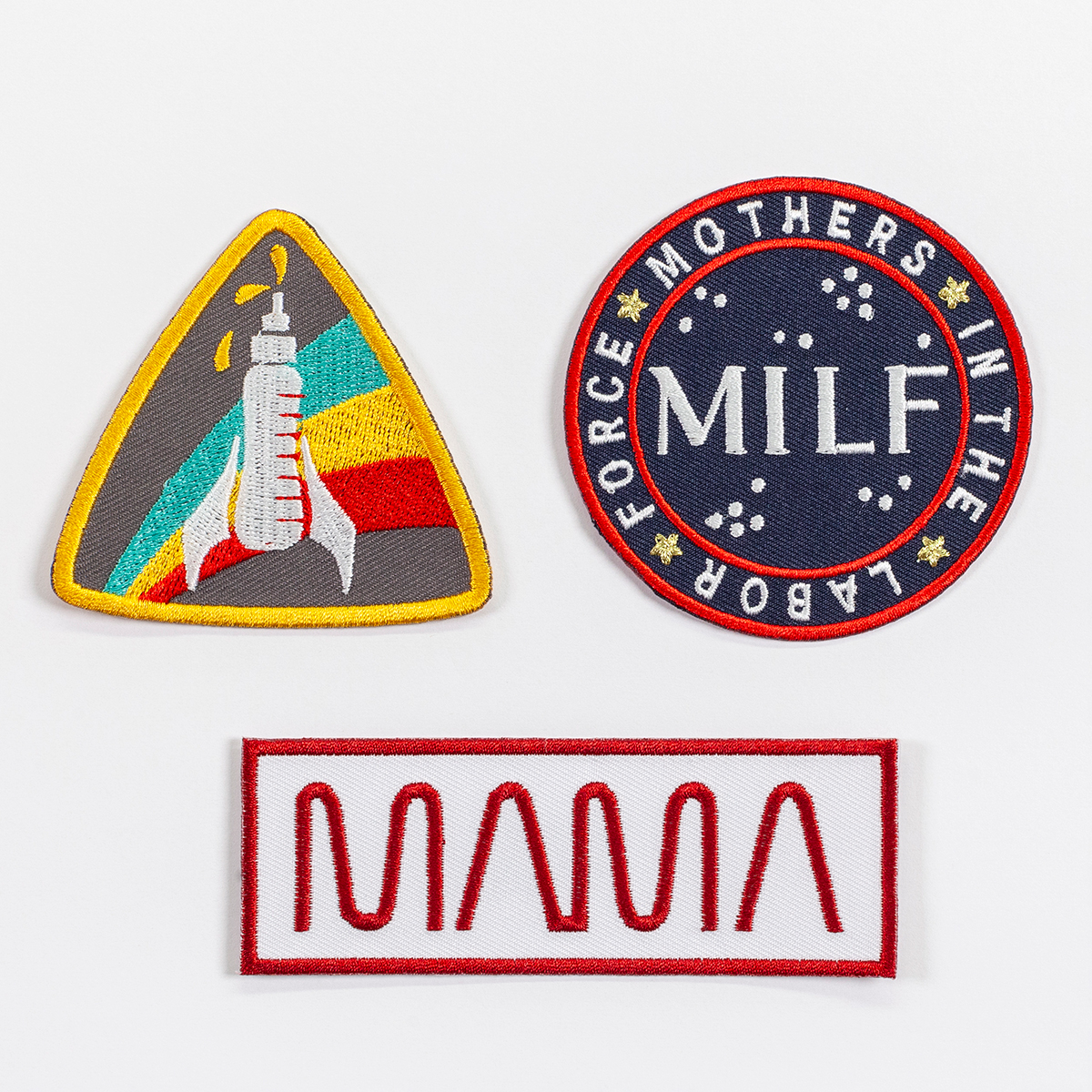 A set of three patches: a triangular patch with rounded corners featuring a baby bottle that looks like a rocket; a circular patch that reads 