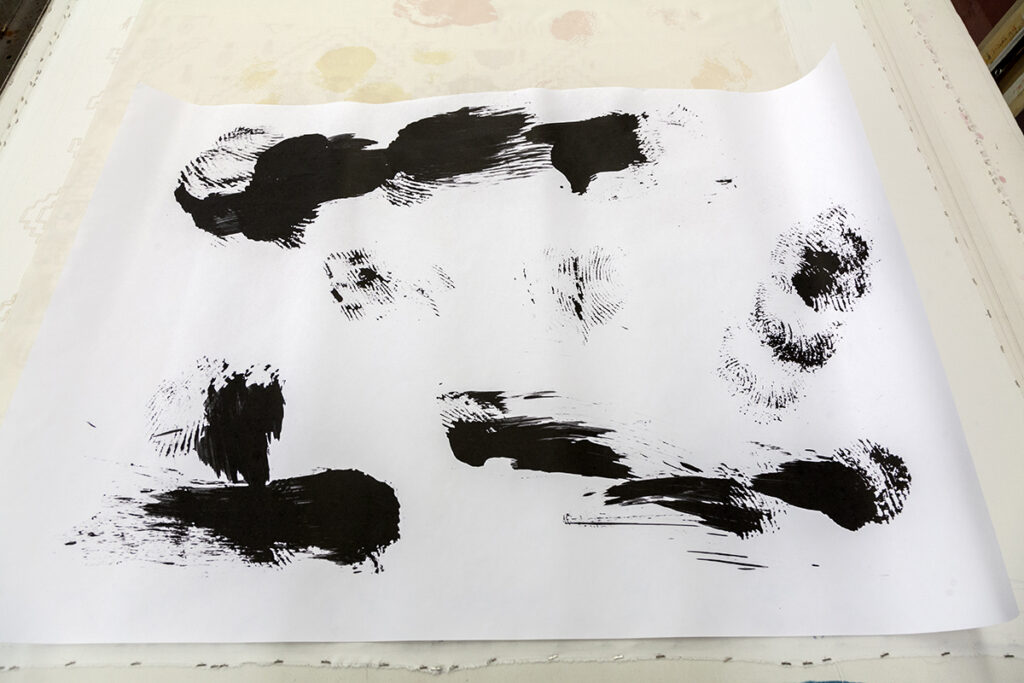 A photo of black finger print-like patterns on paper.