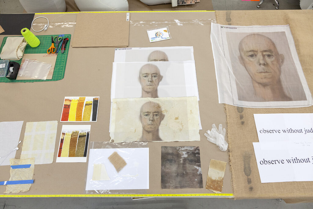 A table spread of material tests and portrait studies featuring an older bald white man.