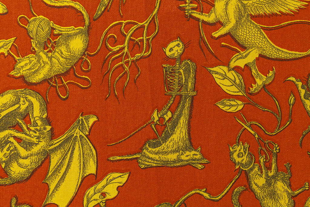 A detail of an illustrated pattern featuring a skeleton of a cat holding its fur coat draped at its feet. Cats with wings, scissors, and balls of twine play among vines and leaves near the periphery. The pattern is composed of three basic colors with a red/orange ground, yellow characters, and dark gray details.