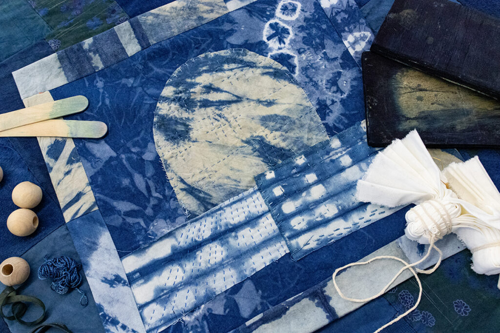 A quilt square patchworked together with indigo-dyed fabrics showing off different indigo dyeing techniques.