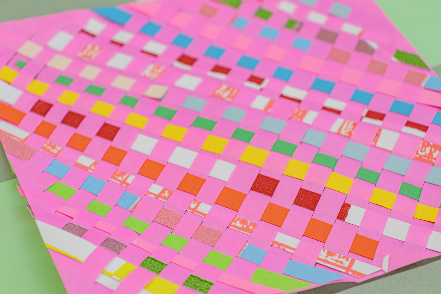 A detailed photo of a multi-colored paper weaving.